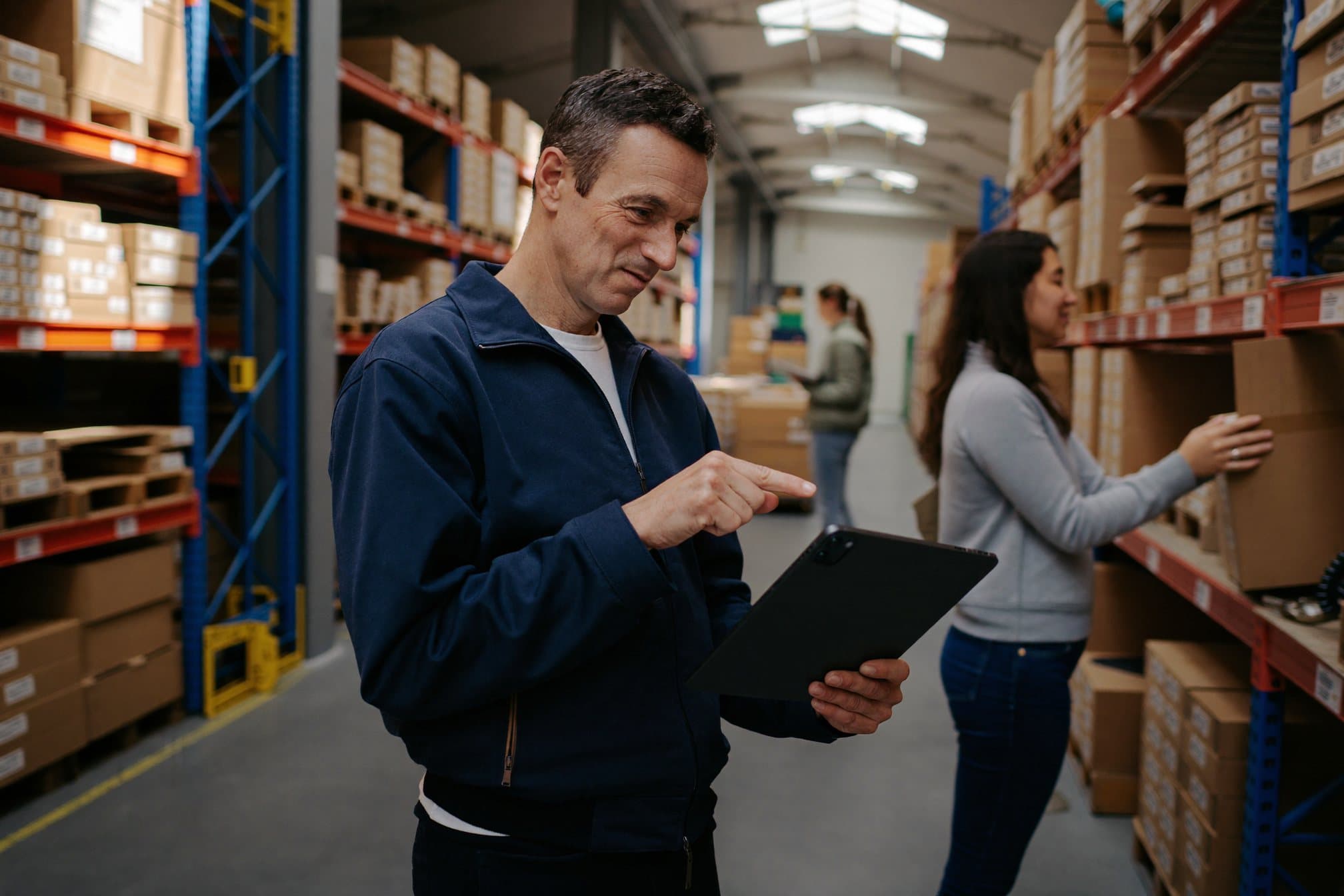 Un responsable d'entrepôt vérifie son stock sur une tablette