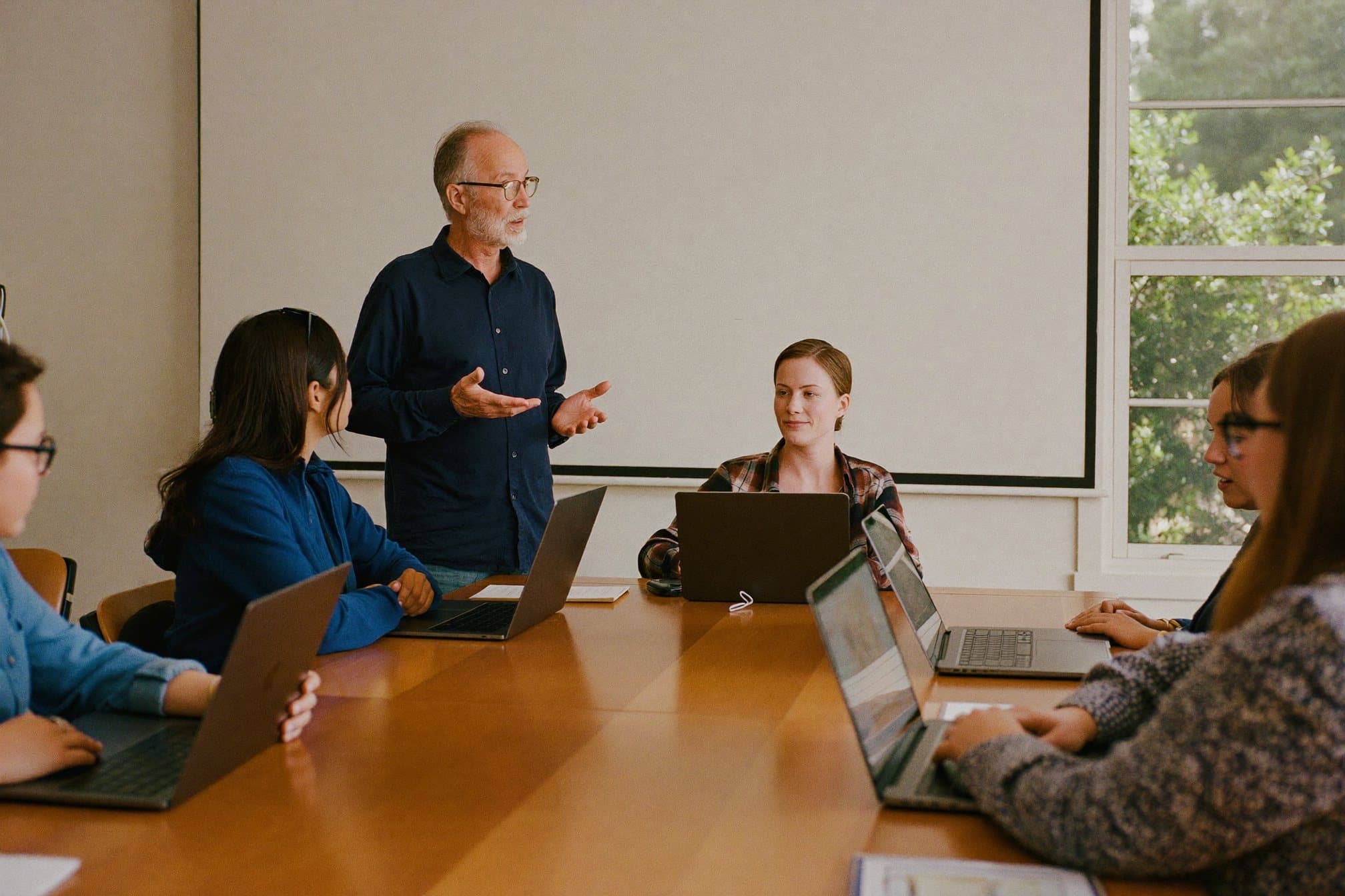 A trainer talks with a small group of adult learners around a table